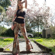 Load image into Gallery viewer, Feel sexy &amp; empower your inner femme fatale in these one of a kind flares! With the ultra high rise waist, these pants are ultra slimming, handcrafted in a unique liquid floral wave print, they feature a contrasting side stripe with golden pyramid studs. Fitted to the knees and flowing out into a super flared hem, just slip on these beauties and have fun mixing + matching them with all of our other knit styles as well as everything else in your wardrobe!
