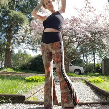 Load image into Gallery viewer, Feel sexy &amp; empower your inner femme fatale in these one of a kind flares! With the ultra high rise waist, these pants are ultra slimming, handcrafted in a unique liquid floral wave print, they feature a contrasting side stripe with golden pyramid studs. Fitted to the knees and flowing out into a super flared hem, just slip on these beauties and have fun mixing + matching them with all of our other knit styles as well as everything else in your wardrobe!
