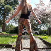 Load image into Gallery viewer, Feel sexy &amp; empower your inner femme fatale in these one of a kind flares! With the ultra high rise waist, these pants are ultra slimming, handcrafted in a unique liquid floral wave print, they feature a contrasting side stripe with golden pyramid studs. Fitted to the knees and flowing out into a super flared hem, just slip on these beauties and have fun mixing + matching them with all of our other knit styles as well as everything else in your wardrobe!
