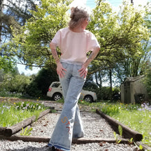 Load image into Gallery viewer, Your wardrobe will thank you and your booty will love you with these 70&#39;s inspired UPCYCLED Driftwood Jeans. Featuring embroidered suede patchwork tuxedo side panels accented with gold studs, also found on the back pockets, and 3 hand embroidered script&#39;s including our signature &#39;LOVED&#39; and &#39;ROCK STAR&#39; found on the bottom back legs, because we all have an inner rock star and we should all feel loved, everyday!
