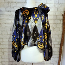 Load image into Gallery viewer, All the romantic vintage feels in this one of a kind avante garde top. Featuring a scoop neckline, long balloon sleeves, a loose flowy hemline and a large rosette on the shoulder. Handcrafted in a blue and golden tone vintage diamond + floral printed velvet, we promise you will truly enjoy slipping on this beauty the very first chance you get!
