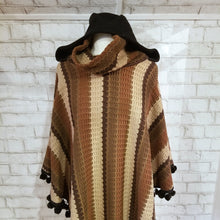 Load image into Gallery viewer, Like a good grounded hug, wrap yourself in this earthtone hooded poncho and you&#39;ll know what me mean! Handcrafted in a unique retro feel cotton crochet, this beautiful poncho features a nice solid feel hood to keep off the rain, quality weighted pom poms gracing the hemline and of course, leather heart elbow patches, your daily reminder that You are Loved!
