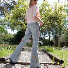 Load image into Gallery viewer, Your wardrobe will thank you and your booty will love you with these 70&#39;s inspired UPCYCLED Driftwood Jeans. Featuring embroidered suede patchwork tuxedo side panels accented with gold studs, also found on the back pockets, and 3 hand embroidered script&#39;s including our signature &#39;LOVED&#39; and &#39;ROCK STAR&#39; found on the bottom back legs, because we all have an inner rock star and we should all feel loved, everyday!
