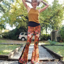 Load image into Gallery viewer, Feel sexy &amp; empower your inner femme fatale in these one of a kind flares! With the ultra high rise waist, these pants are ultra slimming, handcrafted in a unique liquid floral wave print, they feature a contrasting side stripe with golden pyramid studs. Fitted to the knees and flowing out into a super flared hem, just slip on these beauties and have fun mixing + matching them with all of our other knit styles as well as everything else in your wardrobe!
