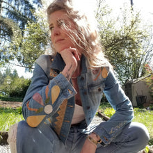 Load image into Gallery viewer, A complete labor of LOVE! This ONE OF A KIND upcycled denim jean jacket is sure to be your new favorite go-to. Featuring dragonfly inspired leather appliqued patchworks throughout the entire jacket in tones of yellow, mauve and earth. The unique vintage scalloped lace down the front and small crochet trim accents are highlighted with 10mm gold pyramid studs. You will also find our signature hand-embroidered &quot;LOVED&quot; script on the left sleeve at the cuff. Scoop up this beauty and feel loved everyday!
