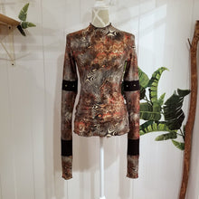 Load image into Gallery viewer, Unique on it&#39;s own or layer up this beauty! A classic fitted mock neck top featuring x-long sleeves, handcrafted in a silky liquid effect floral wave print, ribbed patchwork design boasting gold riveting, each detail as original as the wearer. Slip this beauty on and set your mark for the day!
