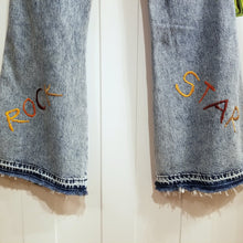 Load image into Gallery viewer, Your wardrobe will thank you and your booty will love you with these 70&#39;s inspired UPCYCLED Driftwood Jeans. Featuring embroidered suede patchwork tuxedo side panels accented with gold studs, also found on the back pockets, and 3 hand embroidered script&#39;s including our signature &#39;LOVED&#39; and &#39;ROCK STAR&#39; found on the bottom back legs, because we all have an inner rock star and we should all feel loved, everyday!
