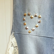 Load image into Gallery viewer, A completely upcycled LEVI denim crop flare jean featuring the sweetest country daisy cotton crochet lace with scalloping along the edges set in a unique asymmetrical detailing, gold + silver hand appliqued studded heart motifs, a one sided cotton eyelet trimmed side seam and 2 of our hand-embroidered LOVED scripts in soft pastel tones of gold, ivory and pink. Scoop up these beauties and feel loved everyday!
