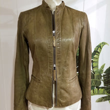 Load image into Gallery viewer, A complete labor of LOVE! This olive green vintage Canadian Brand DANIER leather jacket has been upcycled with a whole lot of love, literally. The sleeve cuffs have been enhanced with a whole bunch of small appliqued leather hearts, twelve to be exact, so unique, and so incredibly One-of-a-Kind. Scoop up this beauty and feel loved everyday!
