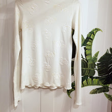 Load image into Gallery viewer, Simply said, this is a beauty, a classic on it&#39;s own or for layering! With the sweet fine ruffle edge finish throughout, this extra long sleeve top and gentle mock neck design will feel delightful on, handcrafted in a sumptuous off-white milky rose embossed print on an organic ever-so-soft cotton. Slip this beauty on and set the tone for the day!
