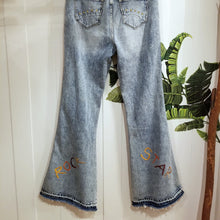 Load image into Gallery viewer, Your wardrobe will thank you and your booty will love you with these 70&#39;s inspired UPCYCLED Driftwood Jeans. Featuring embroidered suede patchwork tuxedo side panels accented with gold studs, also found on the back pockets, and 3 hand embroidered script&#39;s including our signature &#39;LOVED&#39; and &#39;ROCK STAR&#39; found on the bottom back legs, because we all have an inner rock star and we should all feel loved, everyday!
