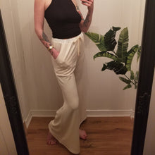 Load image into Gallery viewer, A classic high waist relaxed flare pant for the everyday. Featuring an elasticized waist with drawstring and pockets. Designed for everything from lounging, playing + working whether it&#39;s in your home office or on the go, these pants are so versatile and ultra comfy cozy you won&#39;t want to take them off!
