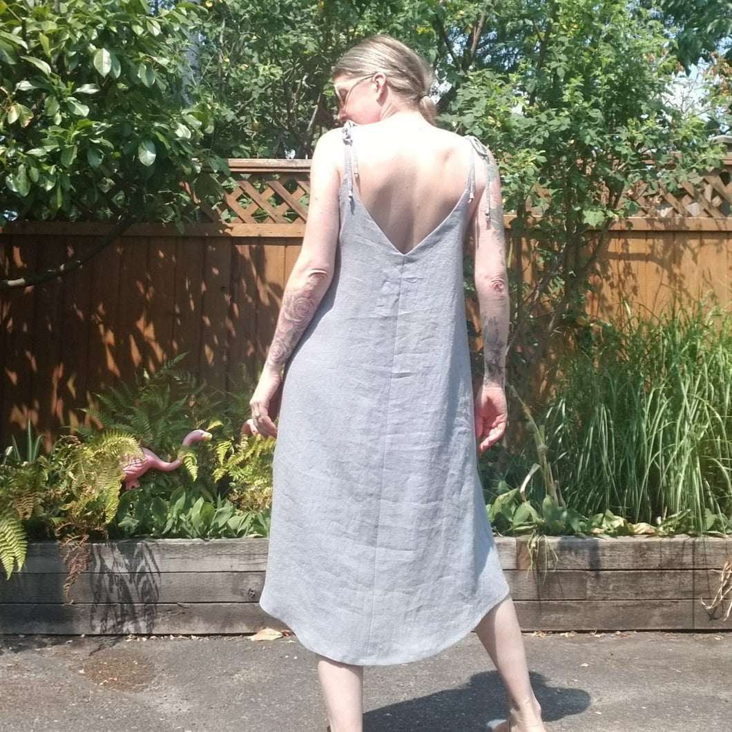 A classic slip on dress for the everyday! Featuring a v-neck front and back with fully self adjustable straps and a loose flowing a-line style body that finishes into a scooping midi length hem. Slip on this beauty and feel the love!