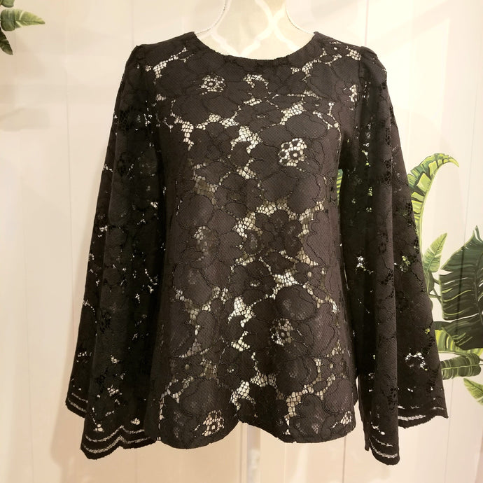 This sweet A-line styled swing top is the perfect piece for any special event! Handcrafted in this luscious black floral lace, it features long bell sleeves with a stunning large scalloped edge finish and a loose swing style body with a semi hi lo scooped hemline. Perfectly easy to slip on and off with the button closure at the back neck, all you need is perhaps a pair of our velvet Luxe Lounge or Flare Pants or one of our skirts for the bottom and your ready to go!