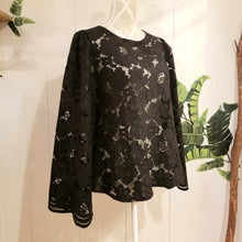 Load image into Gallery viewer, This sweet A-line styled swing top is the perfect piece for any special event! Handcrafted in this luscious black floral lace, it features long bell sleeves with a stunning large scalloped edge finish and a loose swing style body with a semi hi lo scooped hemline. Perfectly easy to slip on and off with the button closure at the back neck, all you need is perhaps a pair of our velvet Luxe Lounge or Flare Pants or one of our skirts for the bottom and your ready to go!
