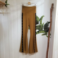 Load image into Gallery viewer, Absolute chic style in these must have flares! Featuring a high rise fitted waistband, this slimming leg pant features a contrasting side stripe with golden pyramid spikes will give you a real sexy and empowering feel. Fitted to the knees and flowing out into a super flared hem, just slip on these classics and have fun mixing + matching them with all of our other knit styles as well as everything else in your wardrobe!
