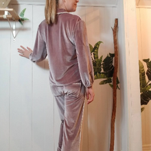 Load image into Gallery viewer, A darling pajama set for everyday. Made in a luxurious stretch velvet, this set features an easy fit top with a sweet peter pan collar trimmed in mini pom poms and a pearl button down front, along with a med-high rise bottom with pockets + side pom pom detailing that runs down the side of this cropped relaxed leg. Perfectly chic for lounging day or night!
