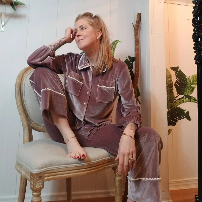 A darling pajama set for everyday. Made in a luxurious stretch velvet, this set features an easy fit top with a sweet peter pan collar trimmed in mini pom poms and a pearl button down front, along with a med-high rise bottom with pockets + side pom pom detailing that runs down the side of this cropped relaxed leg. Perfectly chic for lounging day or night!