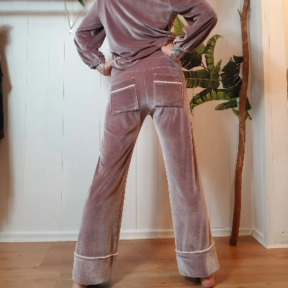 A darling pajama set for everyday. Made in a luxurious stretch velvet, this set features an easy fit top with a sweet peter pan collar trimmed in mini pom poms and a pearl button down front, along with a med-high rise bottom with pockets + side pom pom detailing that runs down the side of this cropped relaxed leg. Perfectly chic for lounging day or night!